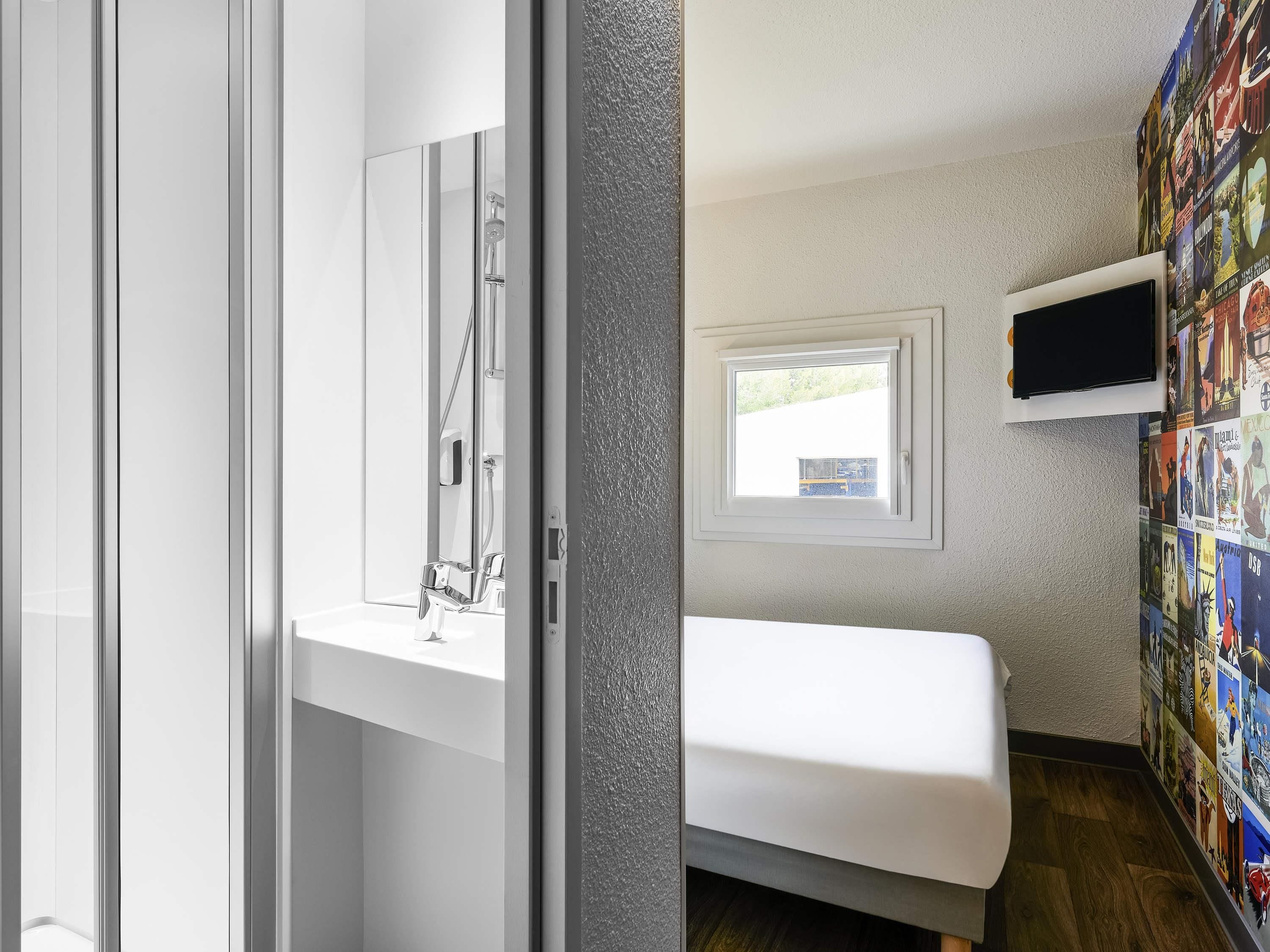 Ein modernes Badezimmer mit Dusche, Toilette und Waschbecken. Ein Fenster bietet Blick ins Freie.