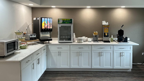 A kitchenette with a microwave, toaster, and coffee machine.