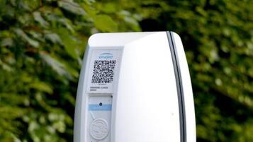 A parking meter with a QR code, payment options, and a digital display.