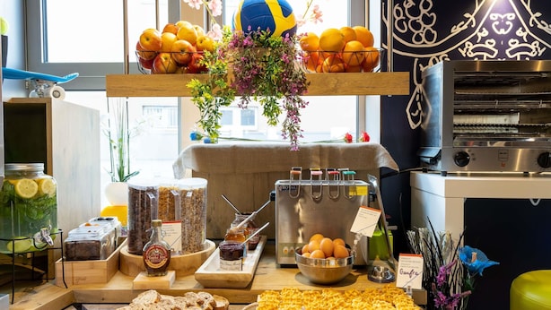 Een ontbijtbuffet met diverse gerechten, een pannenkoekenhoek en een fruitschaal.