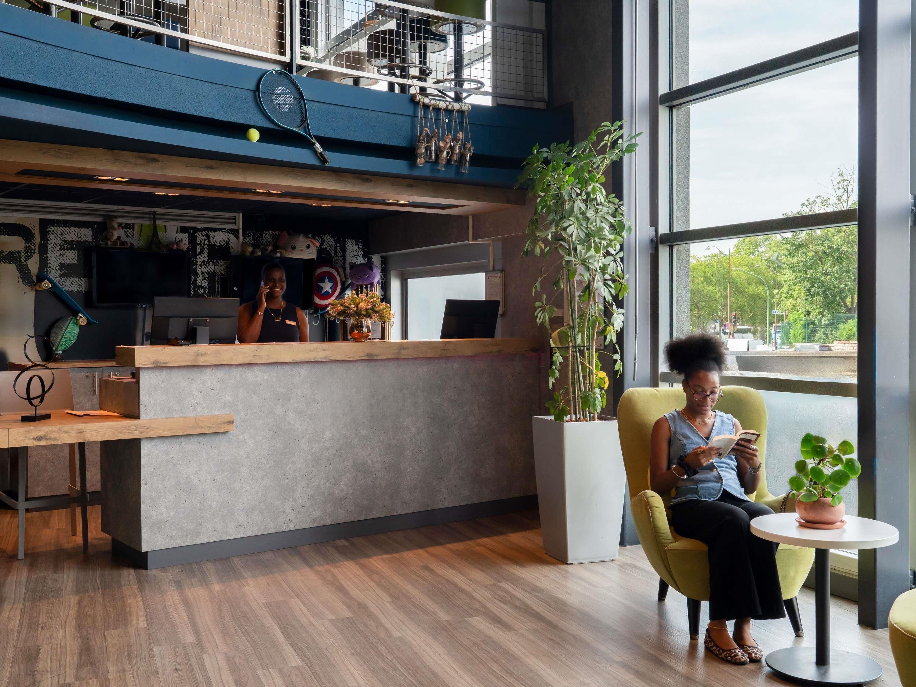 A modern interior with a reception desk, seating area, and large windows.