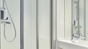 A modern bathroom with a glass shower enclosure, a white sink, and a large mirror. - hotelF1 Clermont-Ferrand East (Clermont-Ferrand)
