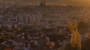 A cityscape at sunset with prominent buildings and a distant mountain range. - hotelF1 Clermont-Ferrand East (Clermont-Ferrand)