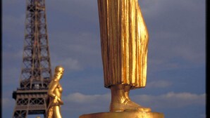 A golden statue with a pedestal, set against a backdrop of the Eiffel Tower. - hotelF1 Paris Saint-Denis Université (Saint-Denis)