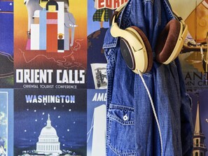 A denim jacket with headphones hanging on it, with a poster in the background. - hotelF1 Toulouse Aéroport (Blagnac)