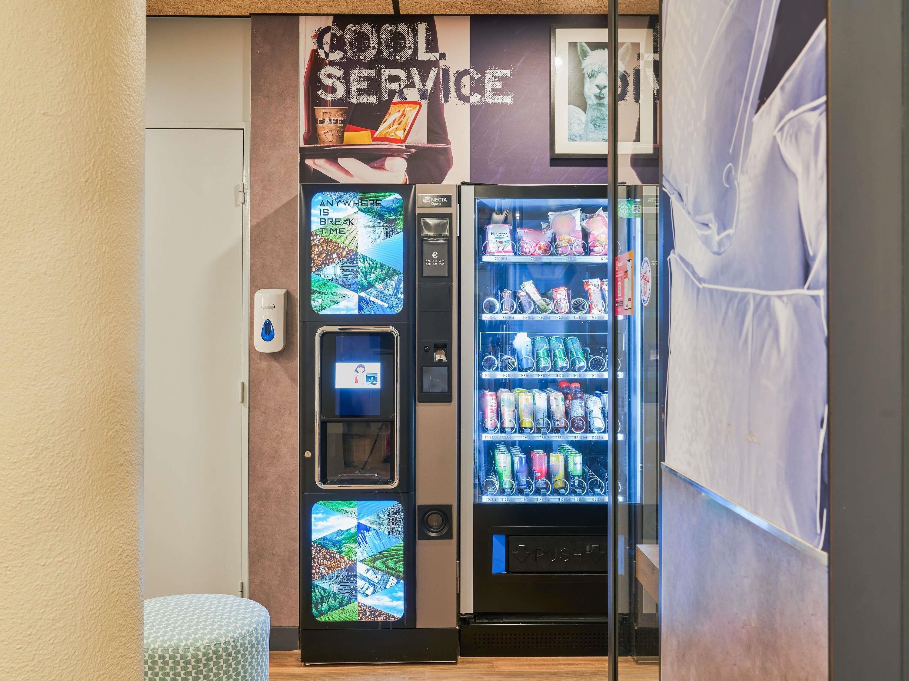 A vending machine with a variety of drinks and snacks, a digital display, and a push button.