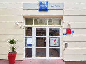 A hotel entrance with a sign for 'ibis budget hotels' and the name 'Saint-Maurice'. - ibis budget Saint Maurice (Saint-Maurice)