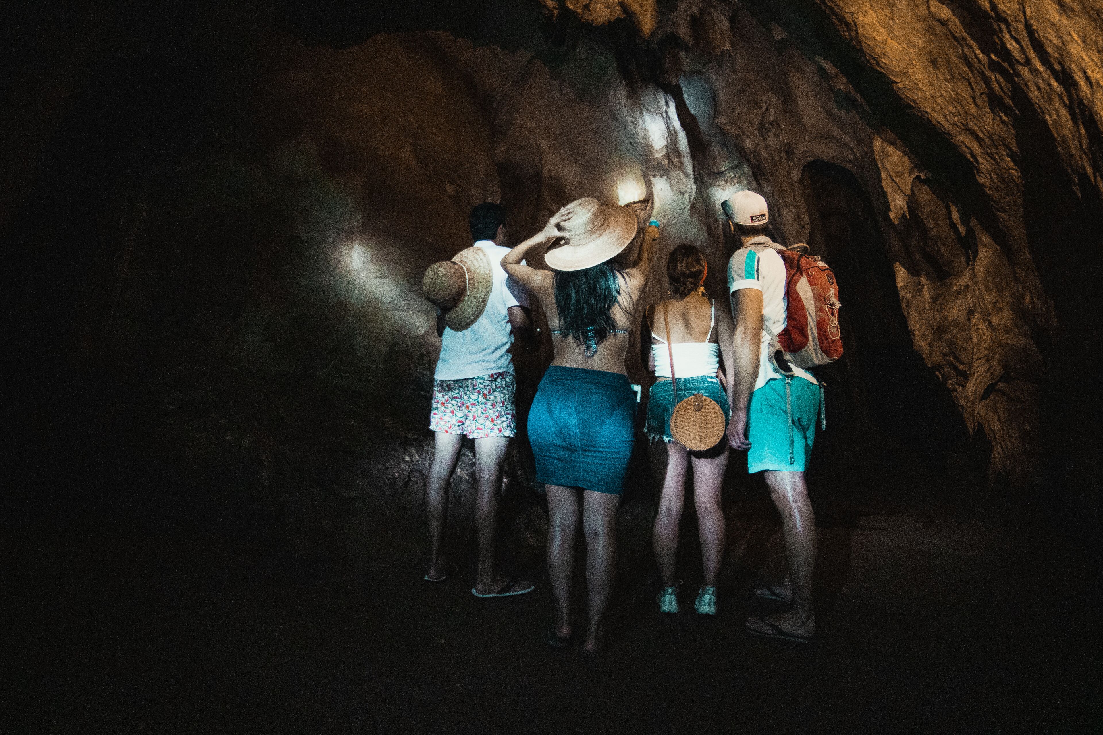 Un grupo de personas en una cueva con paredes rocosas y un estrecho pasadizo.