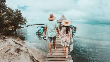 Un muelle de madera que conduce a un embarcadero, con una pareja caminando hacia él.