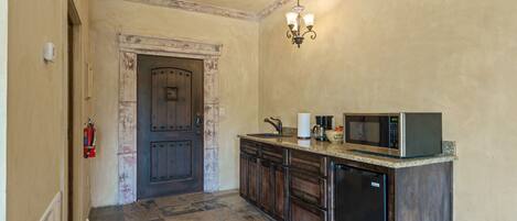 Cocina con puerta de madera, pileta, microondas y lavavajillas.