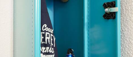 Un locker azul con una toalla colgada en la puerta y una botella de agua azul en su interior.