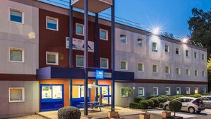 A hotel with a prominent 'ibis budget' sign, multiple windows, and a well-lit entrance. - ibis budget Sucy en Brie (Sucy-en-Brie)