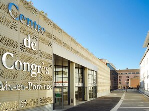 Ein Gebäude mit einer Fassade, die ein geometrisches Muster und den Text 'Centre de Congres Aix-en-Provence' zeigt.