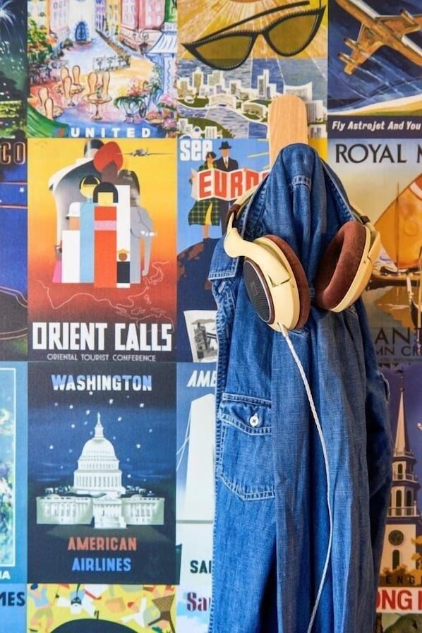 Een muur met verschillende reisposters, waaronder 'Orient Calls', 'American Airlines' en 'Royal'.