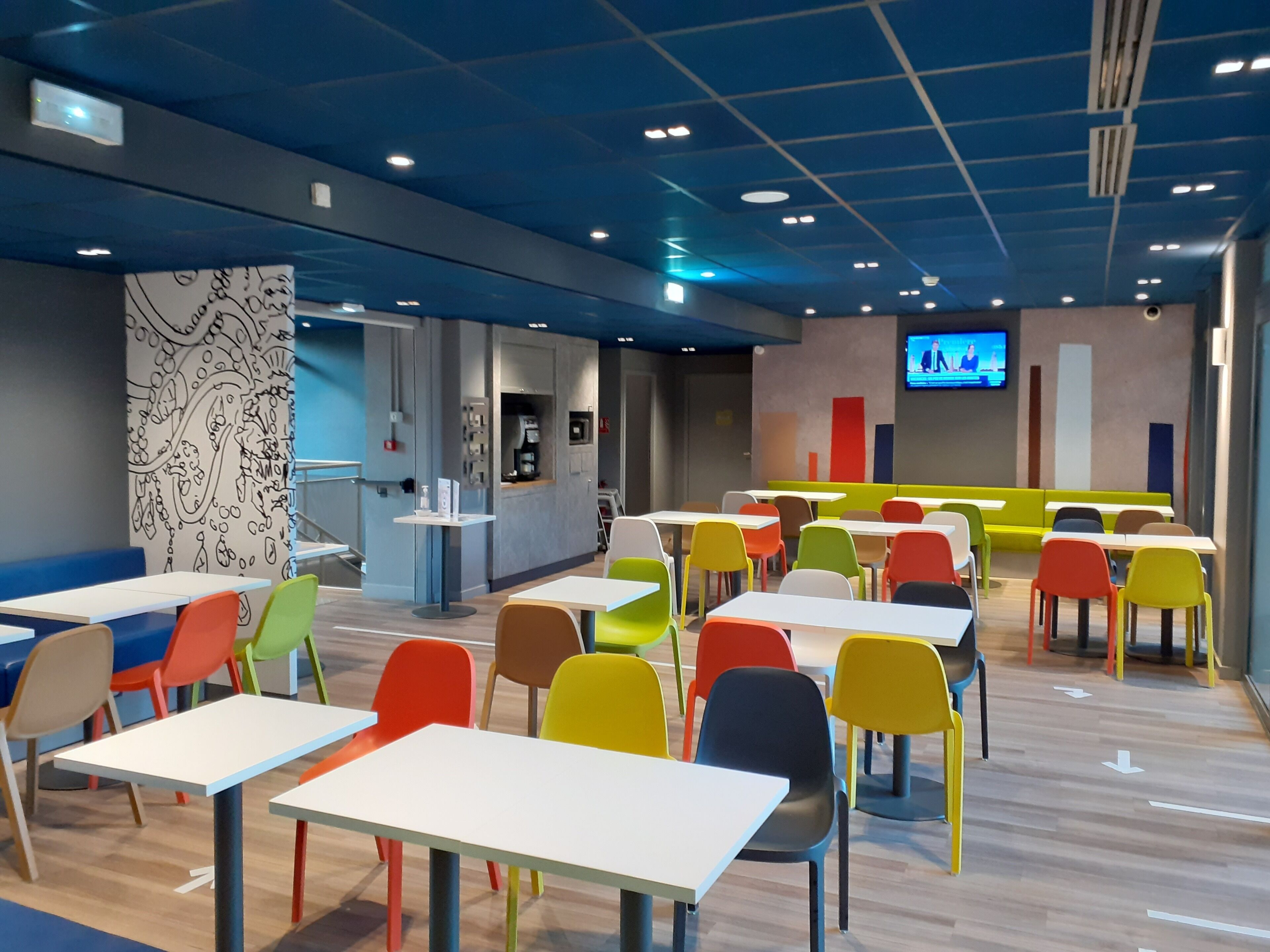 A modern indoor space with tables and chairs arranged for dining.