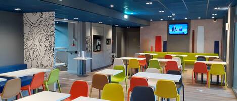 A modern indoor space with tables and chairs arranged for dining.