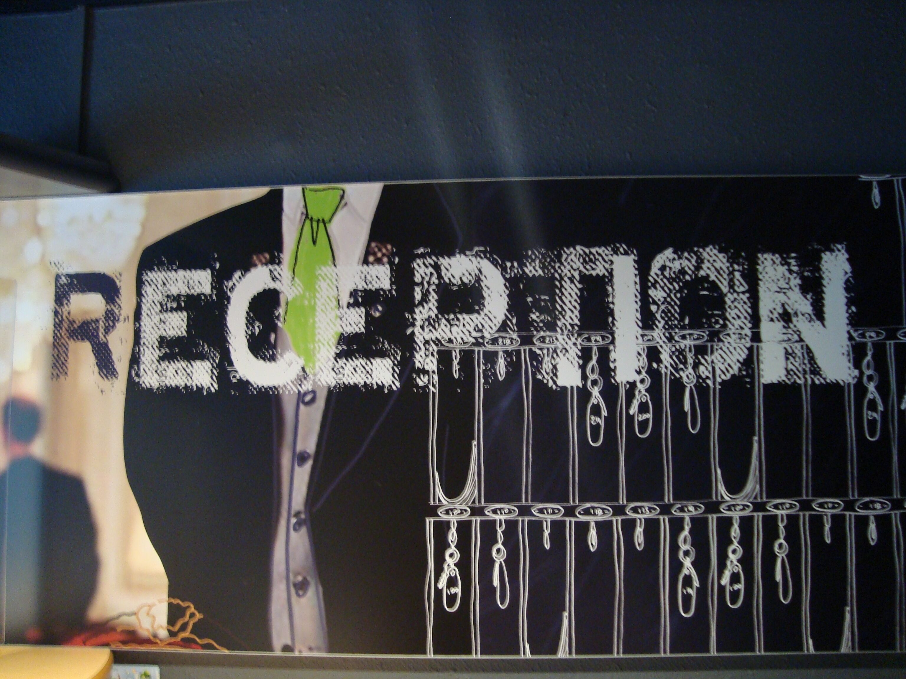 A wall with a poster featuring a man in a suit and tie, and the word "RECEPTION" in large letters.