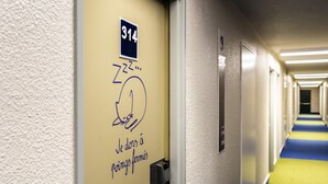 A hotel hallway with a door marked '314' and a blue and yellow carpet. - ibis budget Paris Porte de Bercy (Charenton-le-Pont)