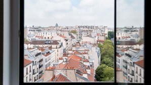 Un paisaje urbano con diversos estilos arquitectónicos y una torre destacada en la distancia.