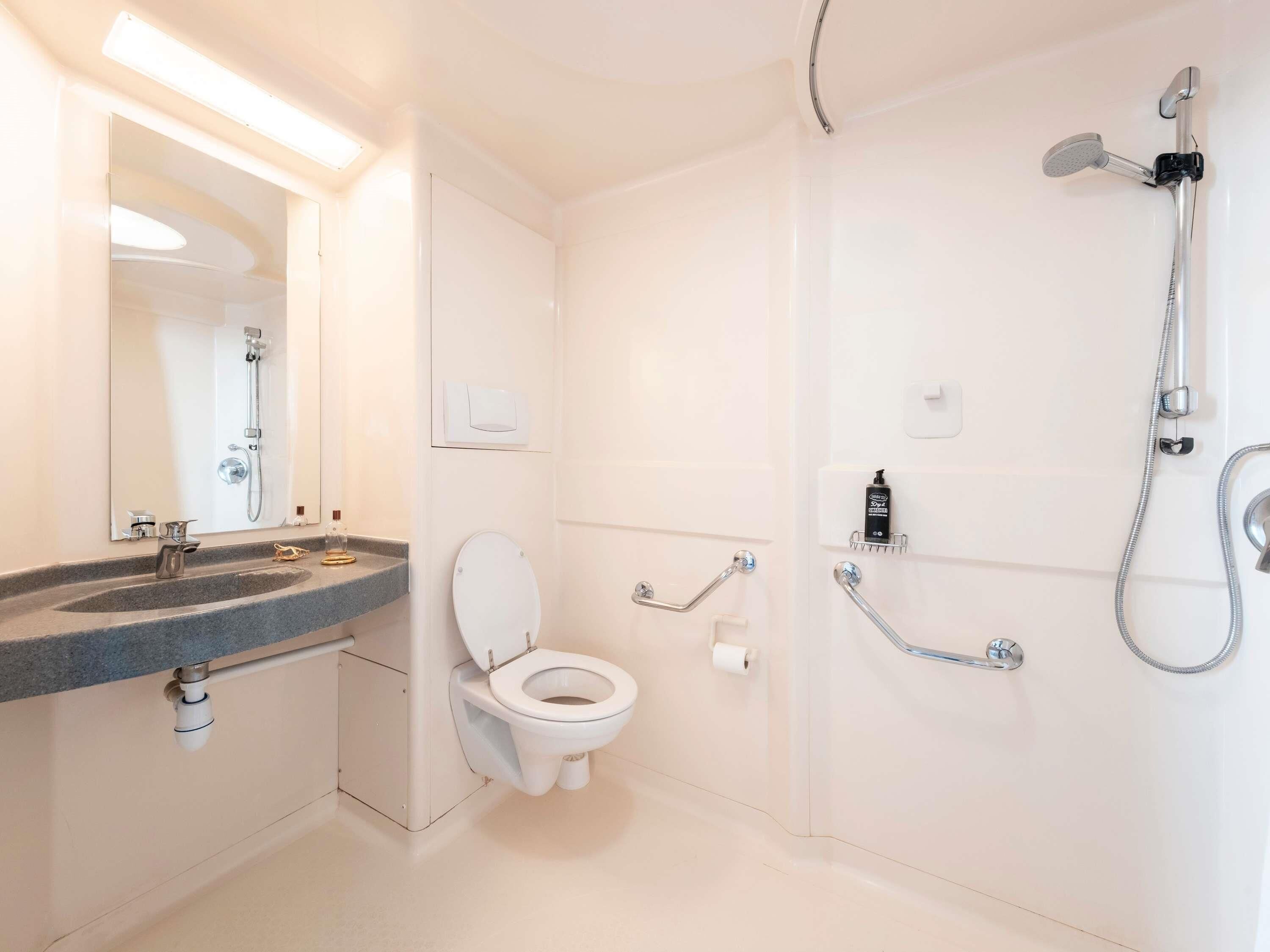 A modern bathroom with a toilet, sink, and shower.