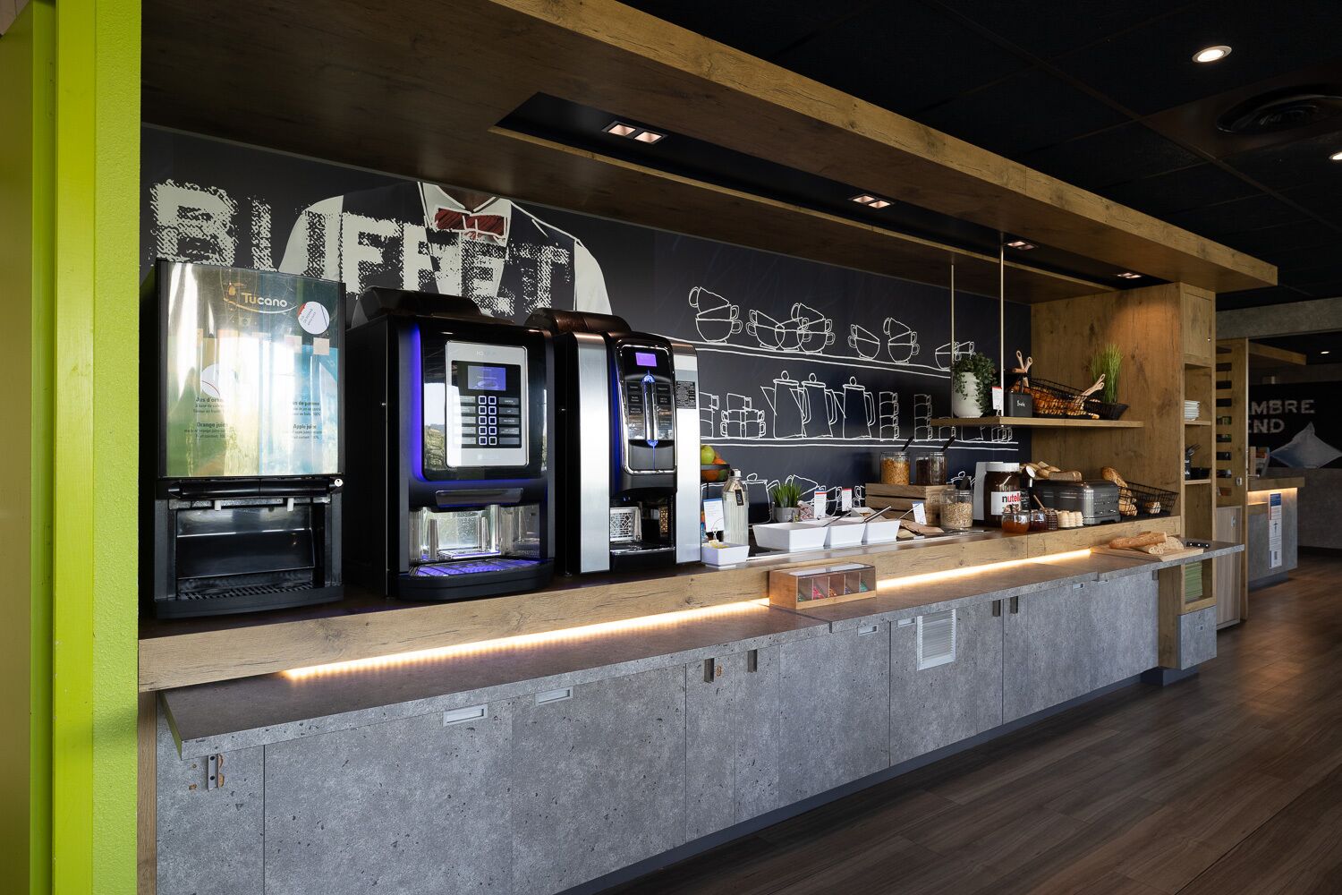 Un bar de cafeteria modern amb màquines d'espresso, un menú de cafè digital i una selecció de grans de cafè i pastissos.
