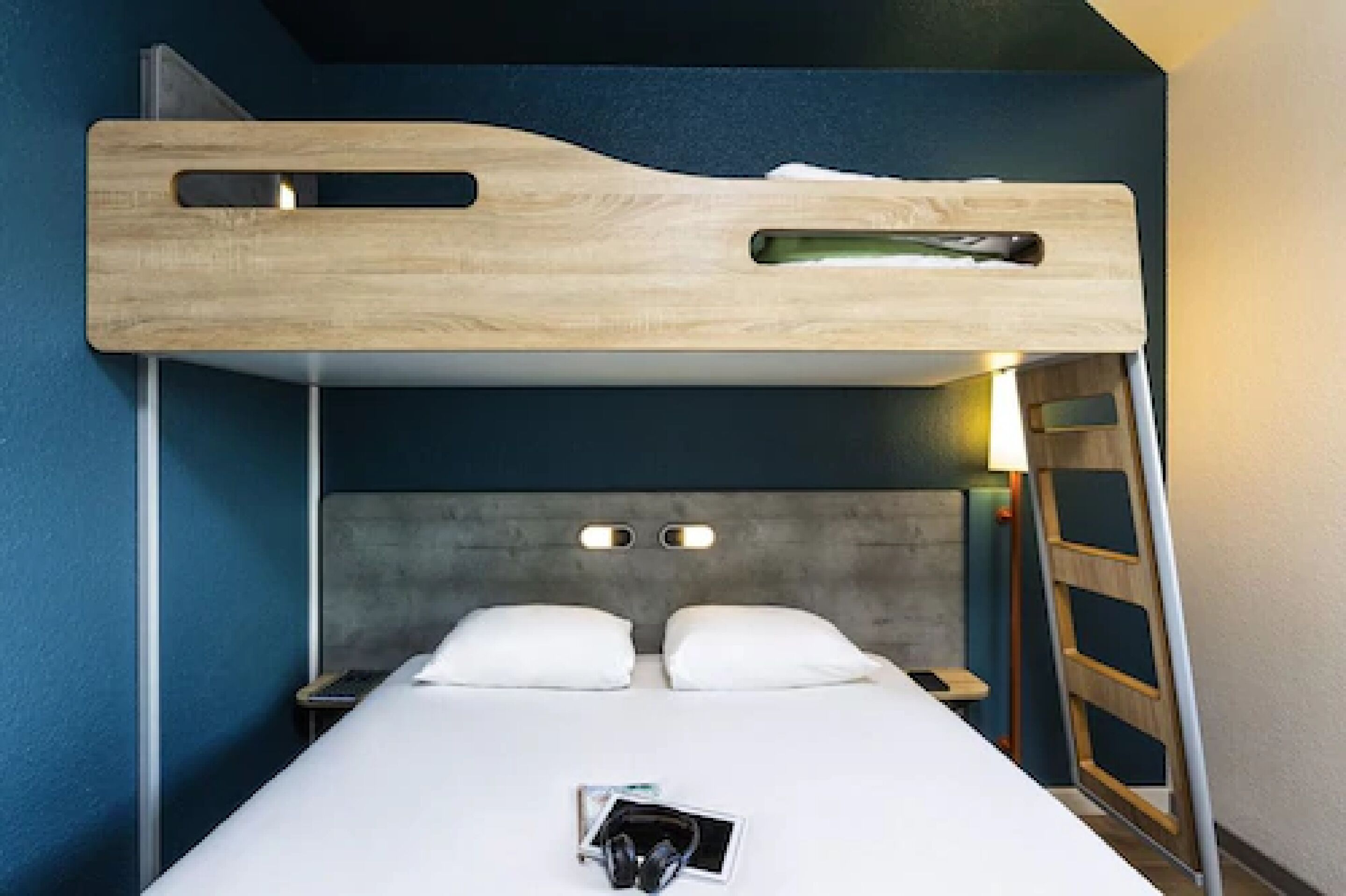 A bunk bed with a wooden headboard, a bedside table, and a nightstand.