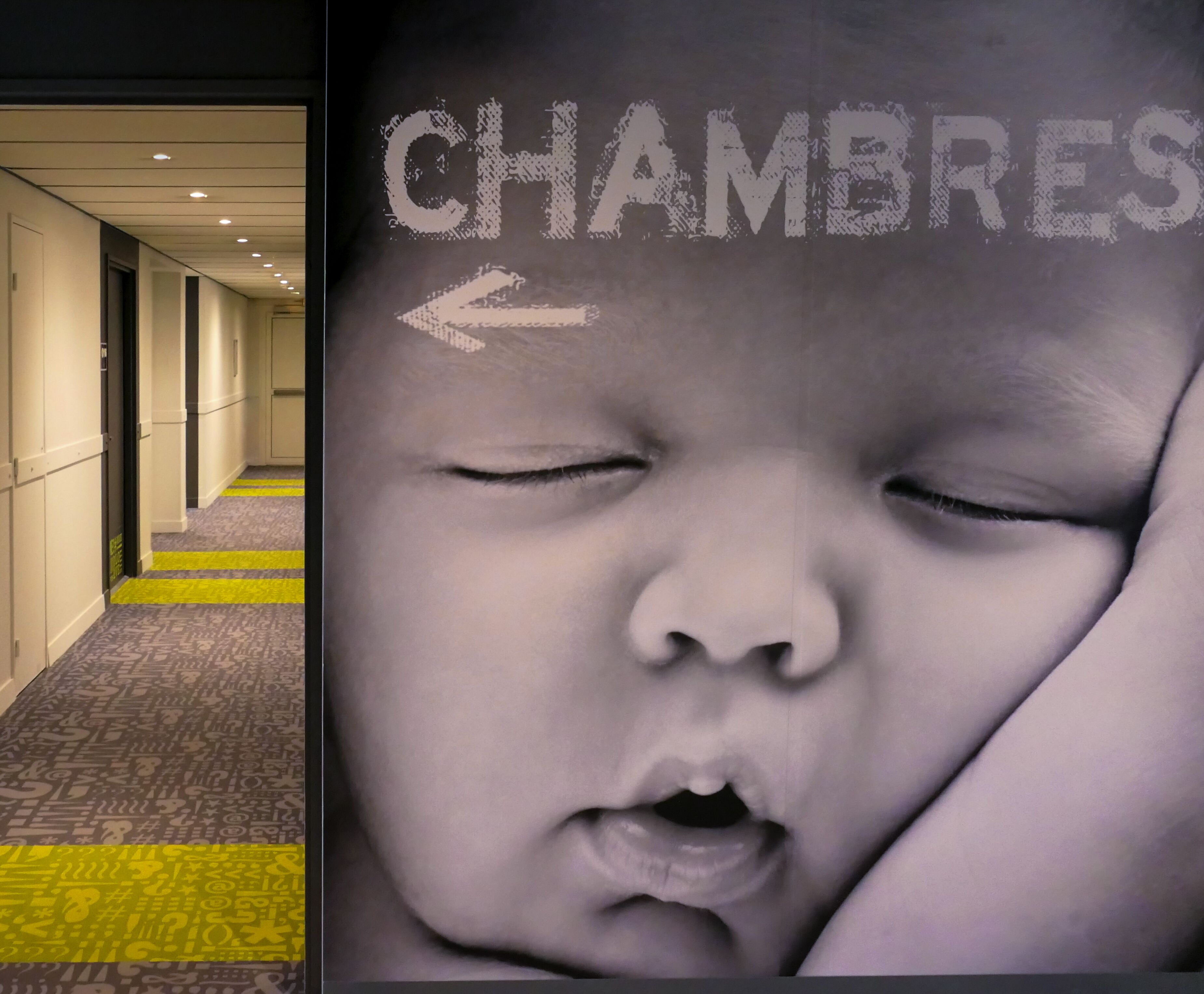 Un pasillo de hotel con un cartel que indica el camino a las habitaciones.