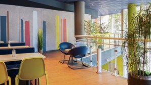 Een modern interieur met een trap, zithoek en een wand met verticale kleurblokken.