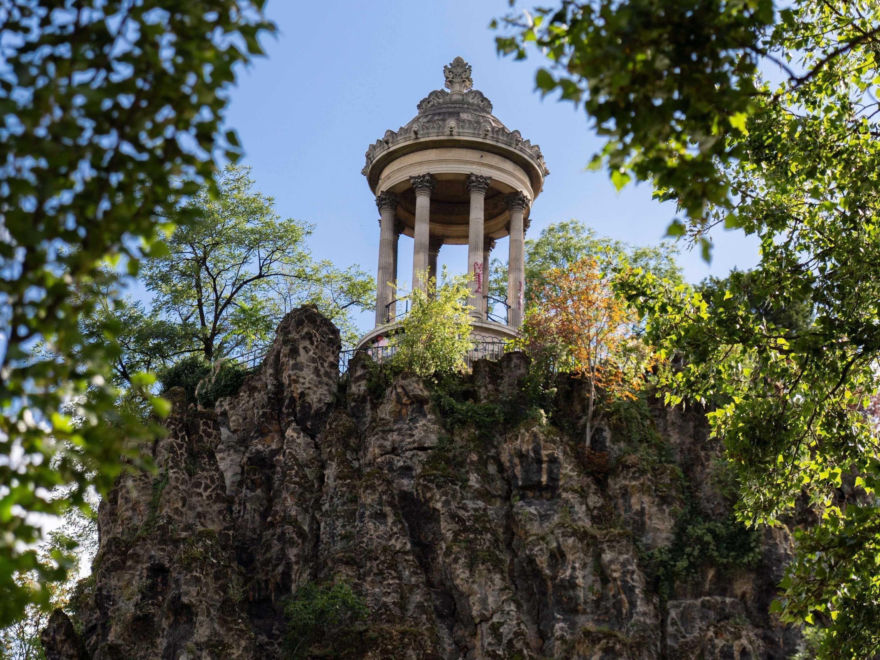 Un pabellón en un promontorio rocoso rodeado de árboles.