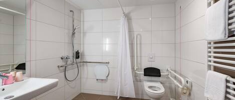 Un baño moderno con ducha, inodoro y lavamanos.
