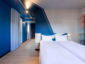 Habitación de hotel moderna con una cama grande, una mesita de noche y un calentador integrado.