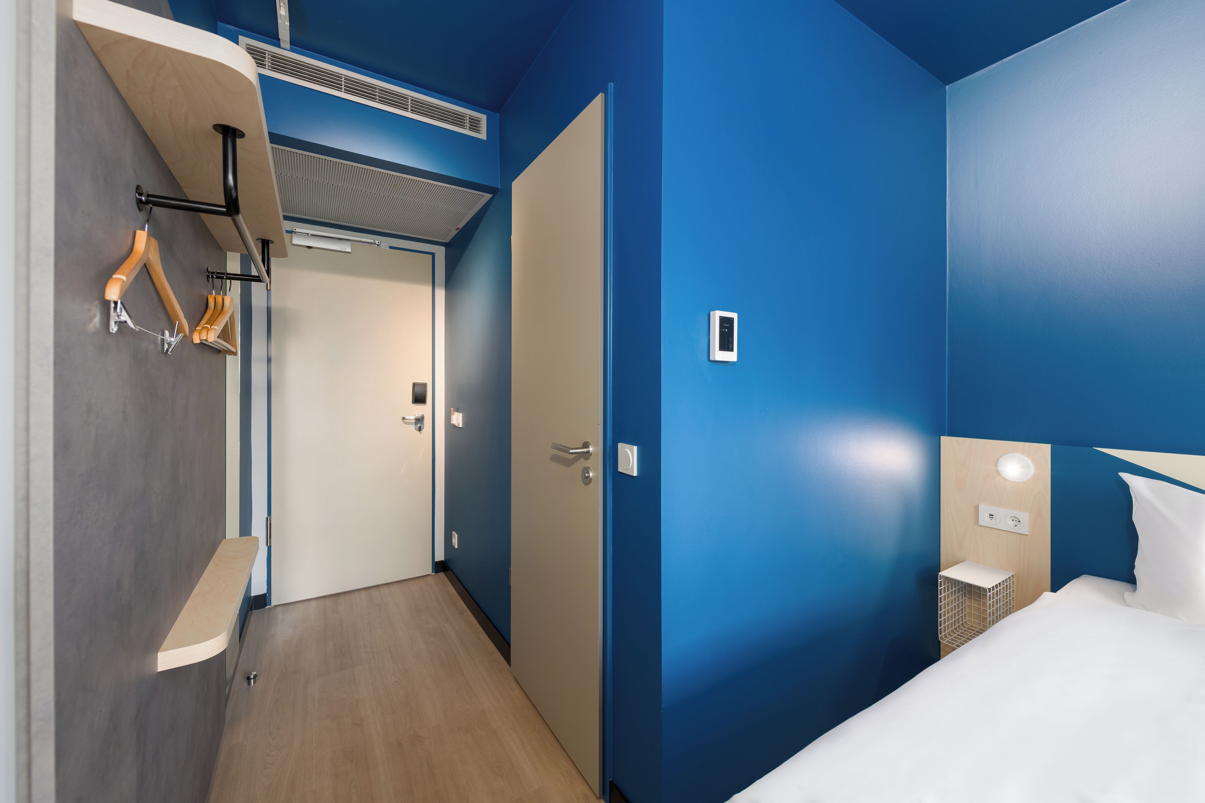 Une chambre d’hôtel comprenant un lit, une table de chevet, une armoire et une salle de bain.