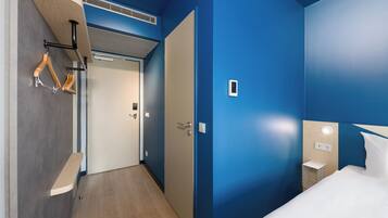 Une chambre d’hôtel comprenant un lit, une table de chevet, une armoire et une salle de bain.