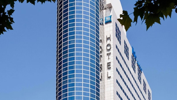 A hotel with a modern glass facade and a classic white exterior.