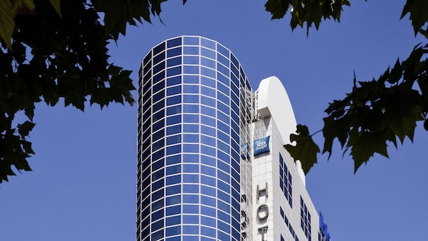 A hotel with a modern glass facade, a prominent 'HOTEL' sign, and a 'TIBIS' logo. - ibis budget Paris Porte de Montreuil (Montreuil)