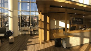A modern interior with a reception desk, seating area, and large windows.