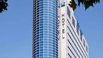 A hotel with a modern glass facade and a classic white exterior.