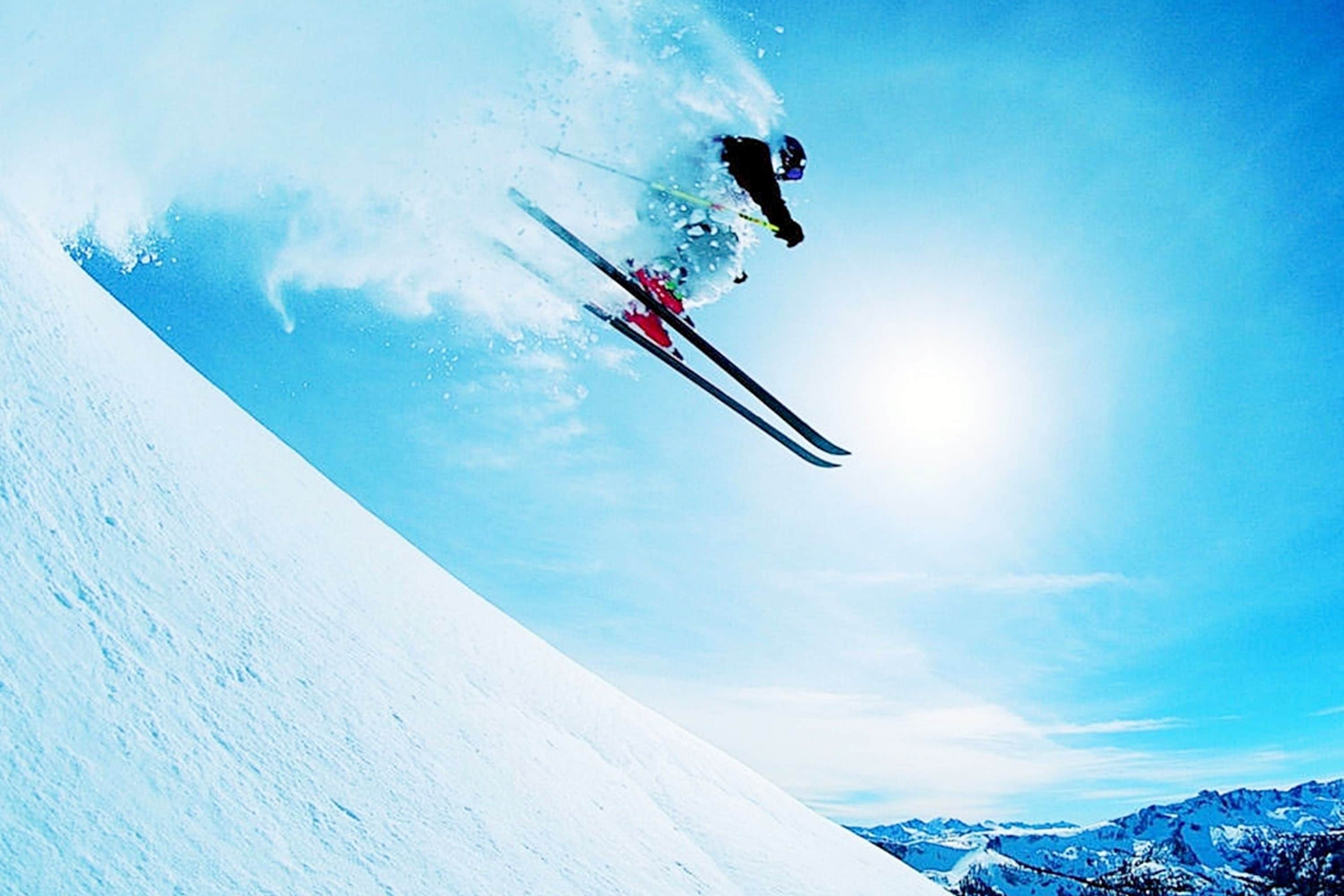Ein Skifahrer springt in der Luft über einen verschneiten Hang.