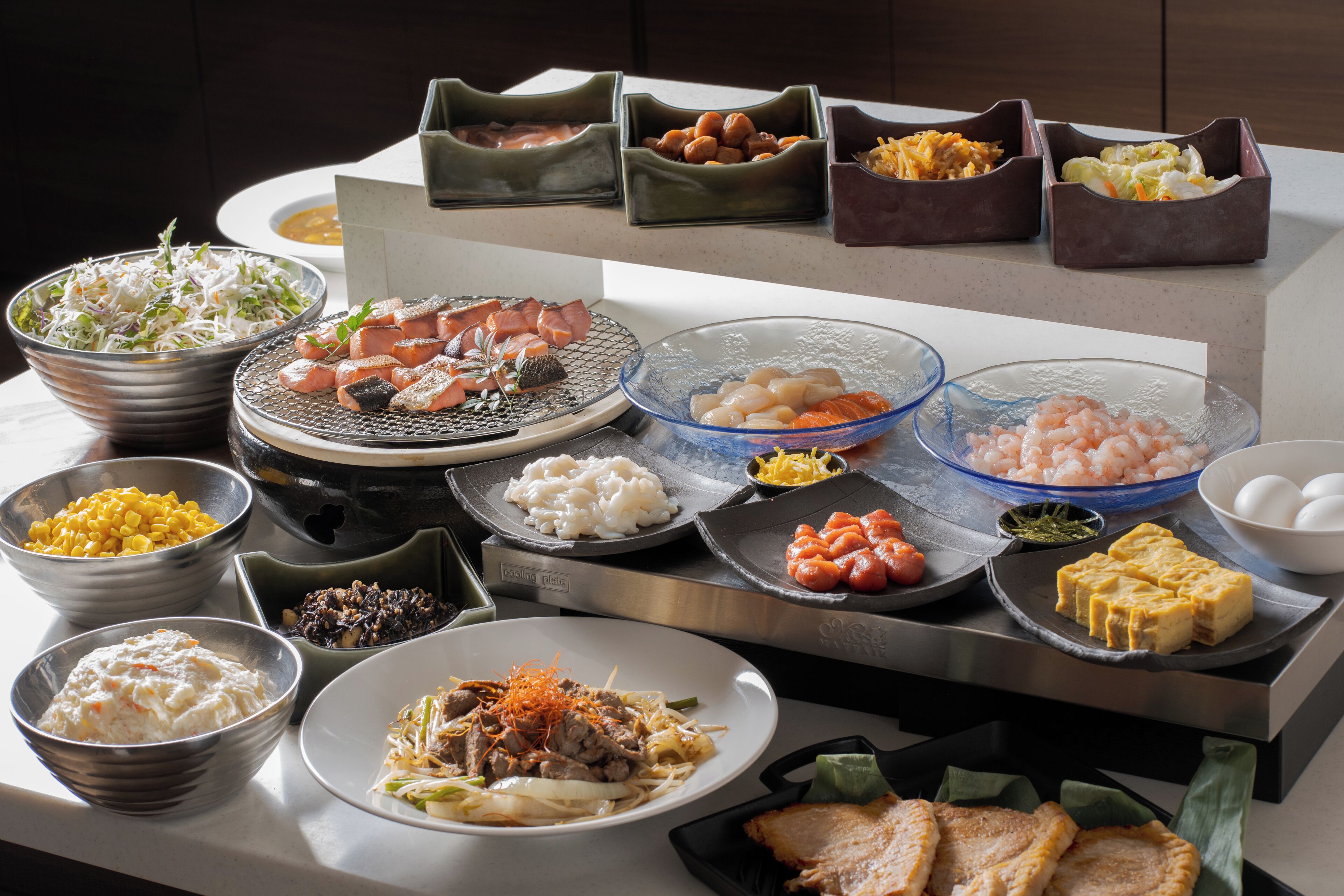 A buffet table with various dishes including seafood, rice, and vegetables.
