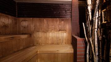 A sauna with wooden benches and a brick wall.