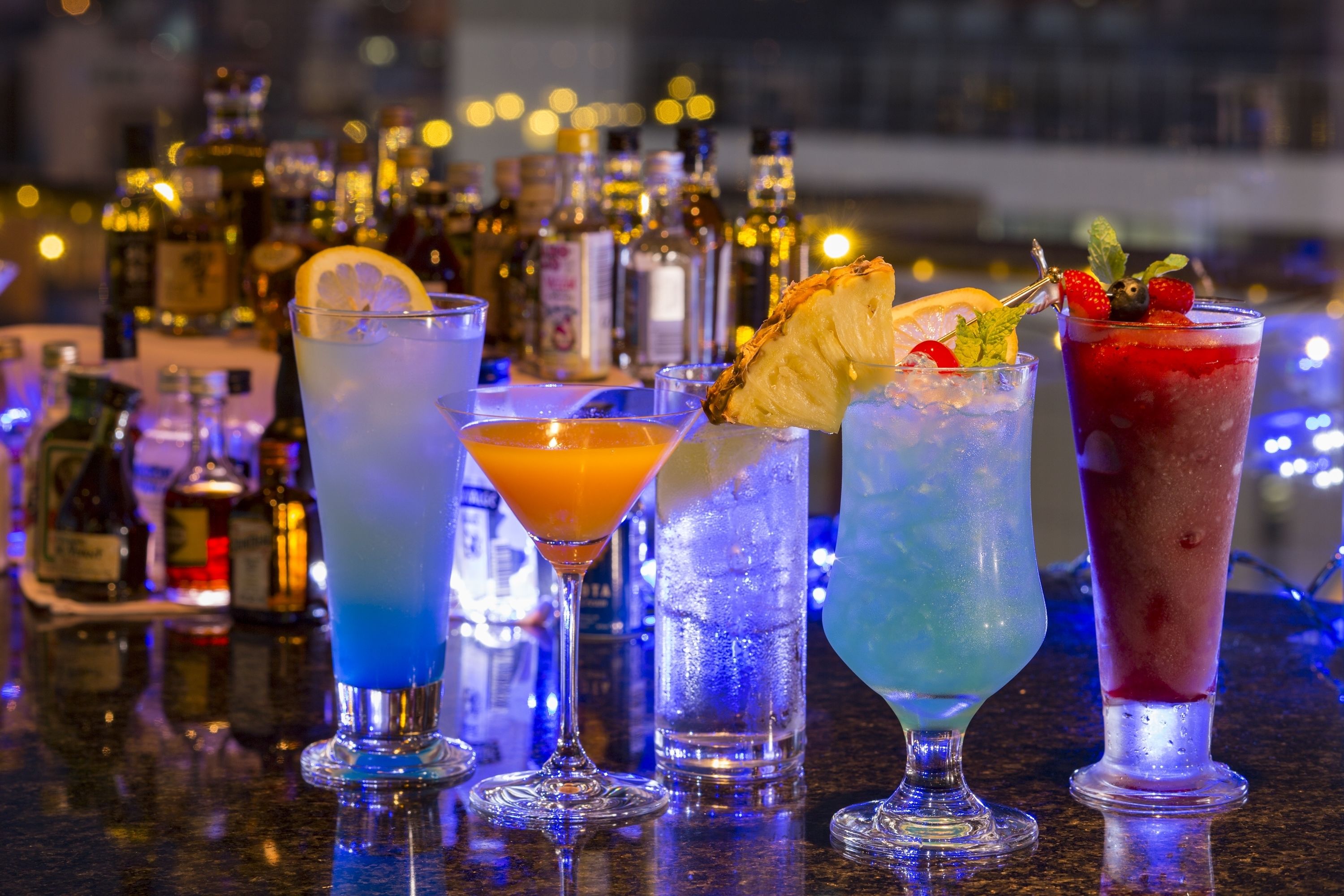 A bar with various cocktails and bottles of liquor.
