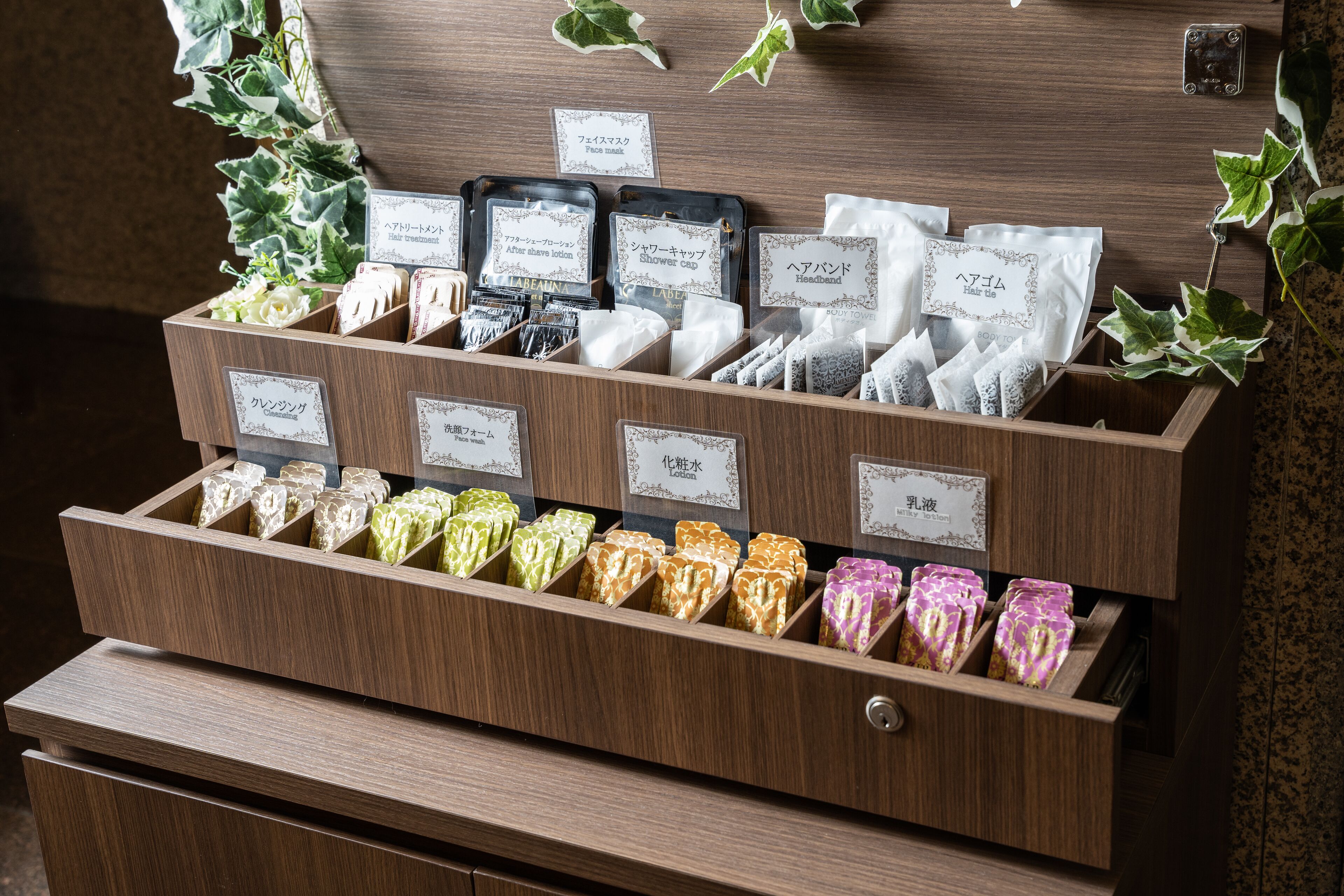 A wooden display case with various toiletries and personal care items, including face masks, shower caps, and hairbands.