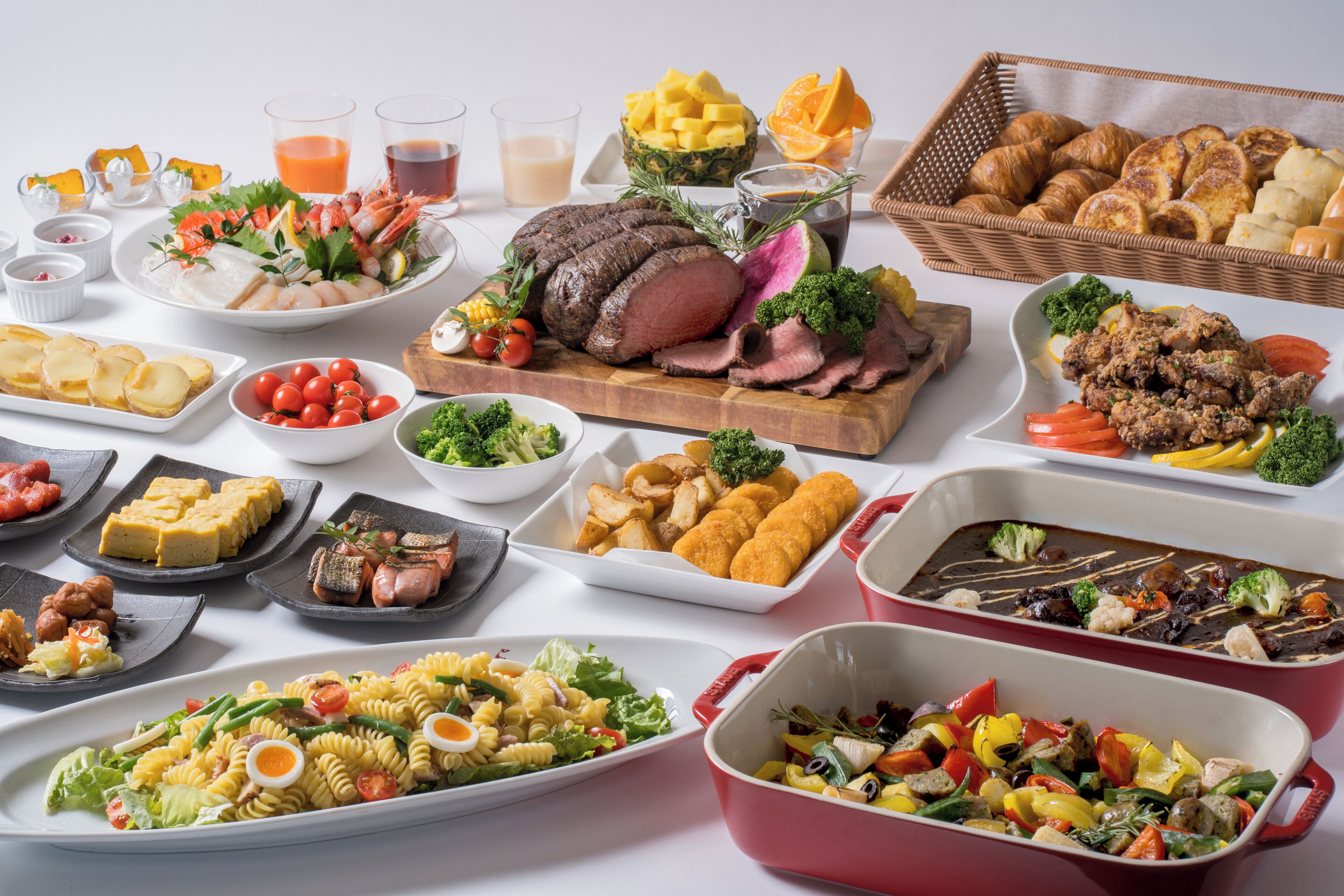 A variety of dishes including a roasted beef centerpiece, pasta salad, and assorted side dishes.