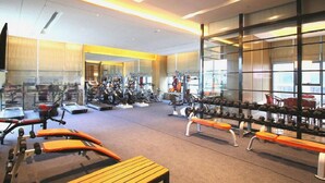 A gym with exercise equipment, benches, and a mirrored wall. - Sanya Shuangda Adelaide In Resort Hotel (Sanya)