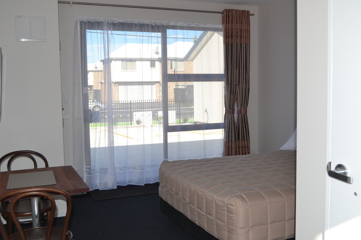 Un dormitorio con cama, escritorio y silla.