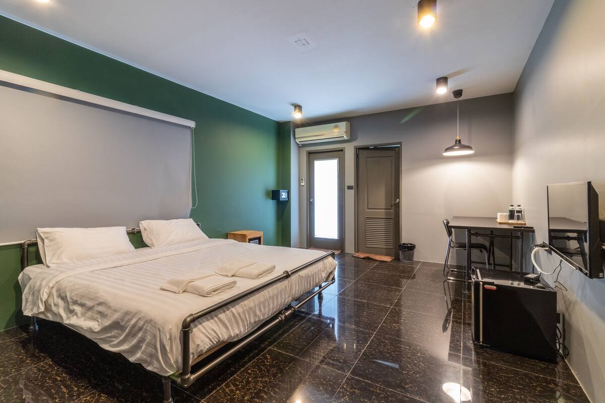 A hotel room with a bed, a desk, and a chair.