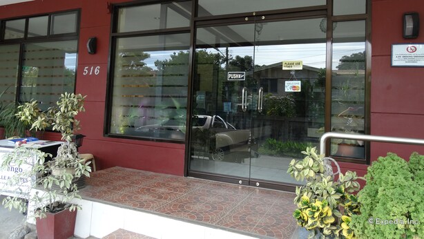A building with a red exterior, large glass windows, and a door marked "PUSH". - RueMango Apartelle and Suites (Davao)