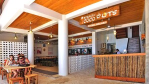 Un restaurant avec un plafond en bois et une enseigne indiquant « Boracay Coco Cottages », proposant des chambres à la location.