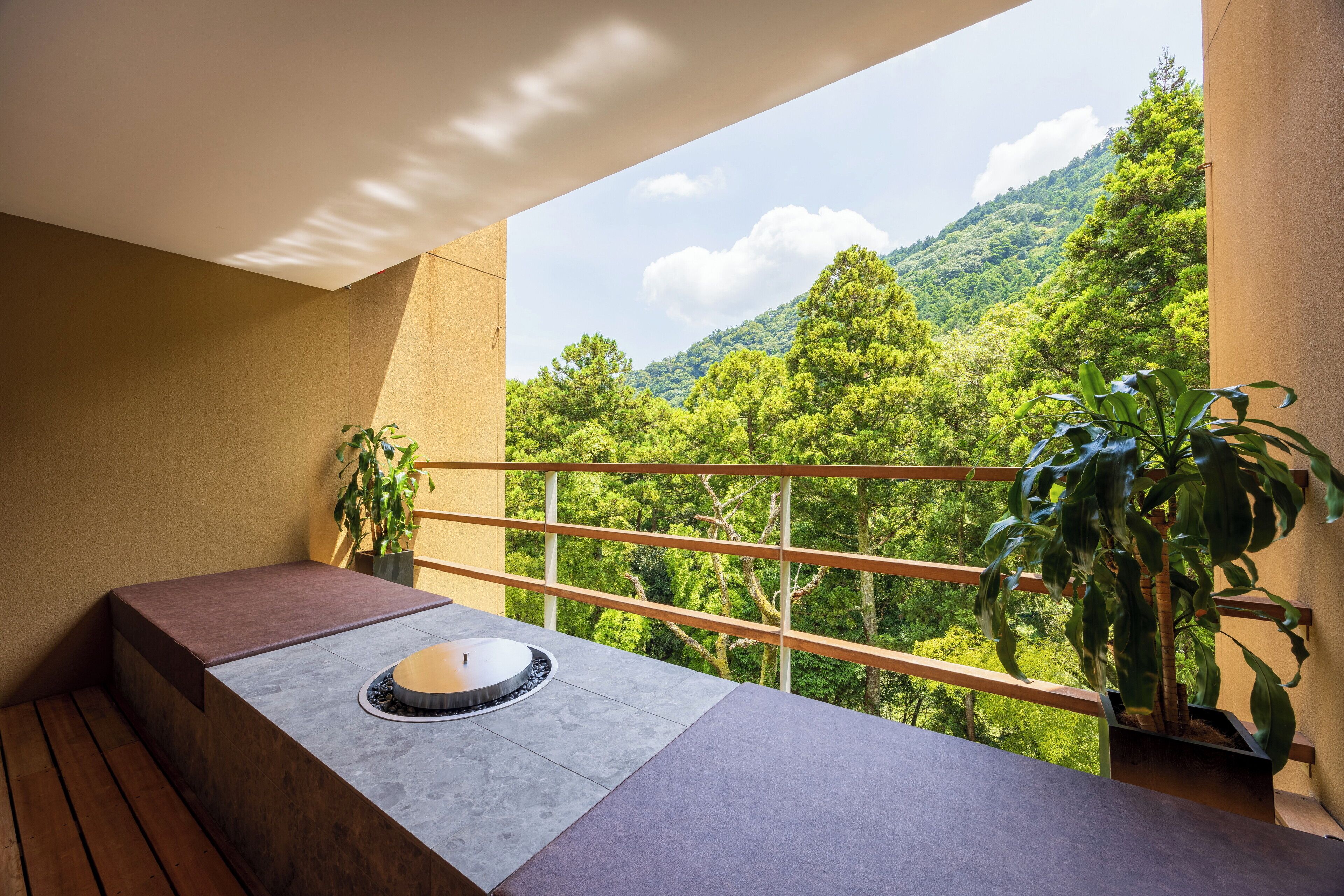 Uma varanda com uma pia de pedra, um banco de madeira e plantas em vasos.