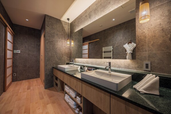 Une salle de bain moderne avec deux vasques, des meubles en bois et un grand miroir.